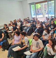 Aula piena di studenti attenti e concentrati, atmosfera di apprendimento vivace.
